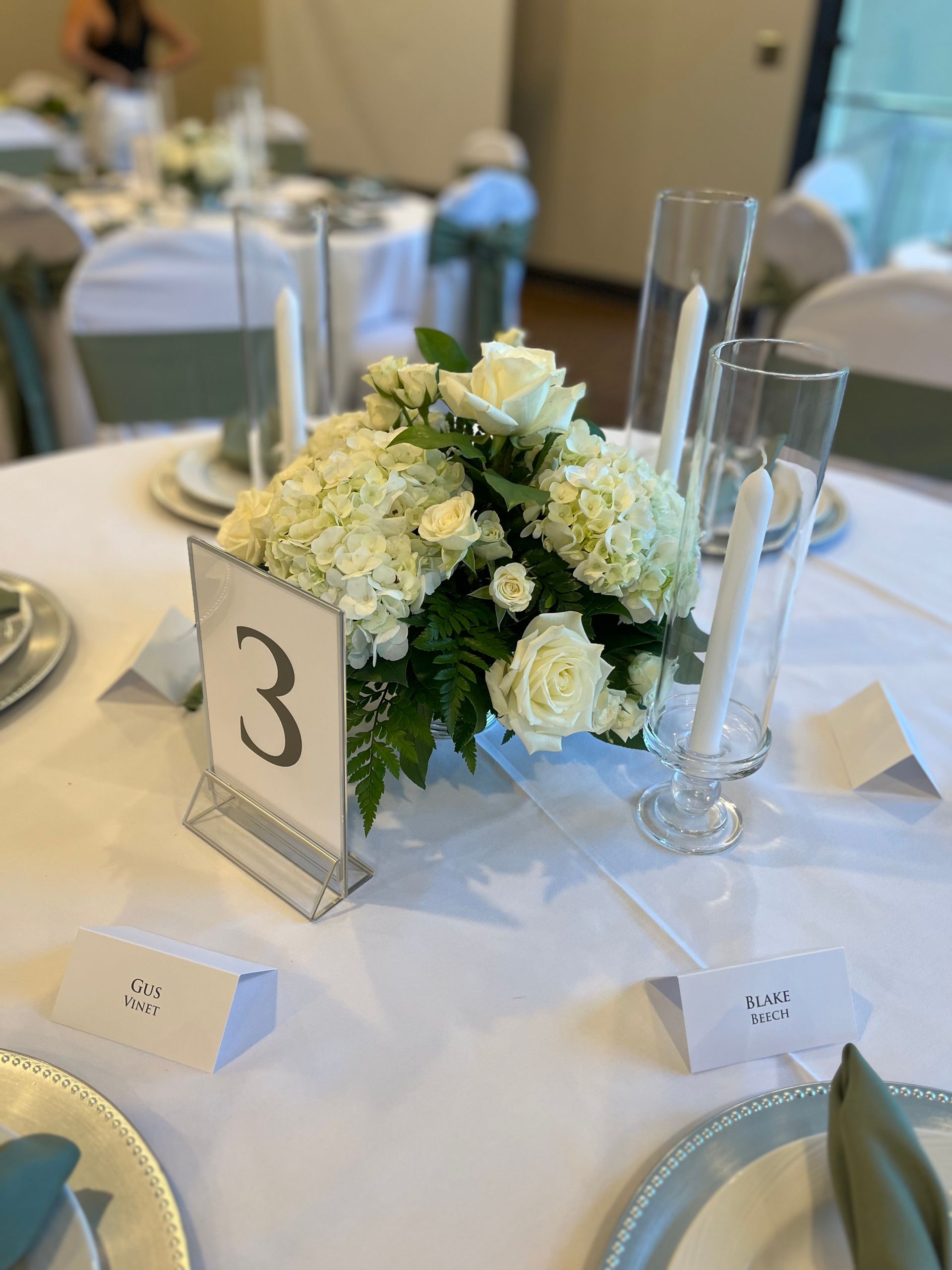 A table with flowers and candles and a table number 3