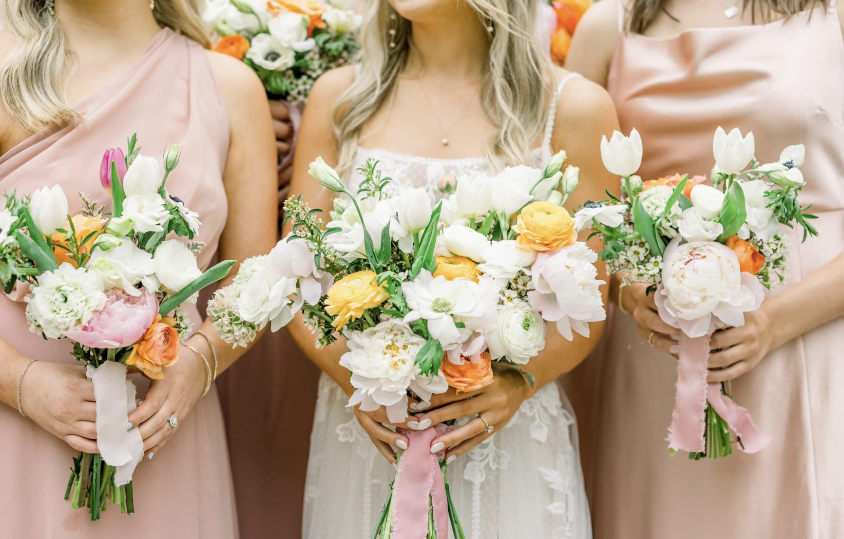 A bride and her bridesmaids are holding bouquets of flowers.