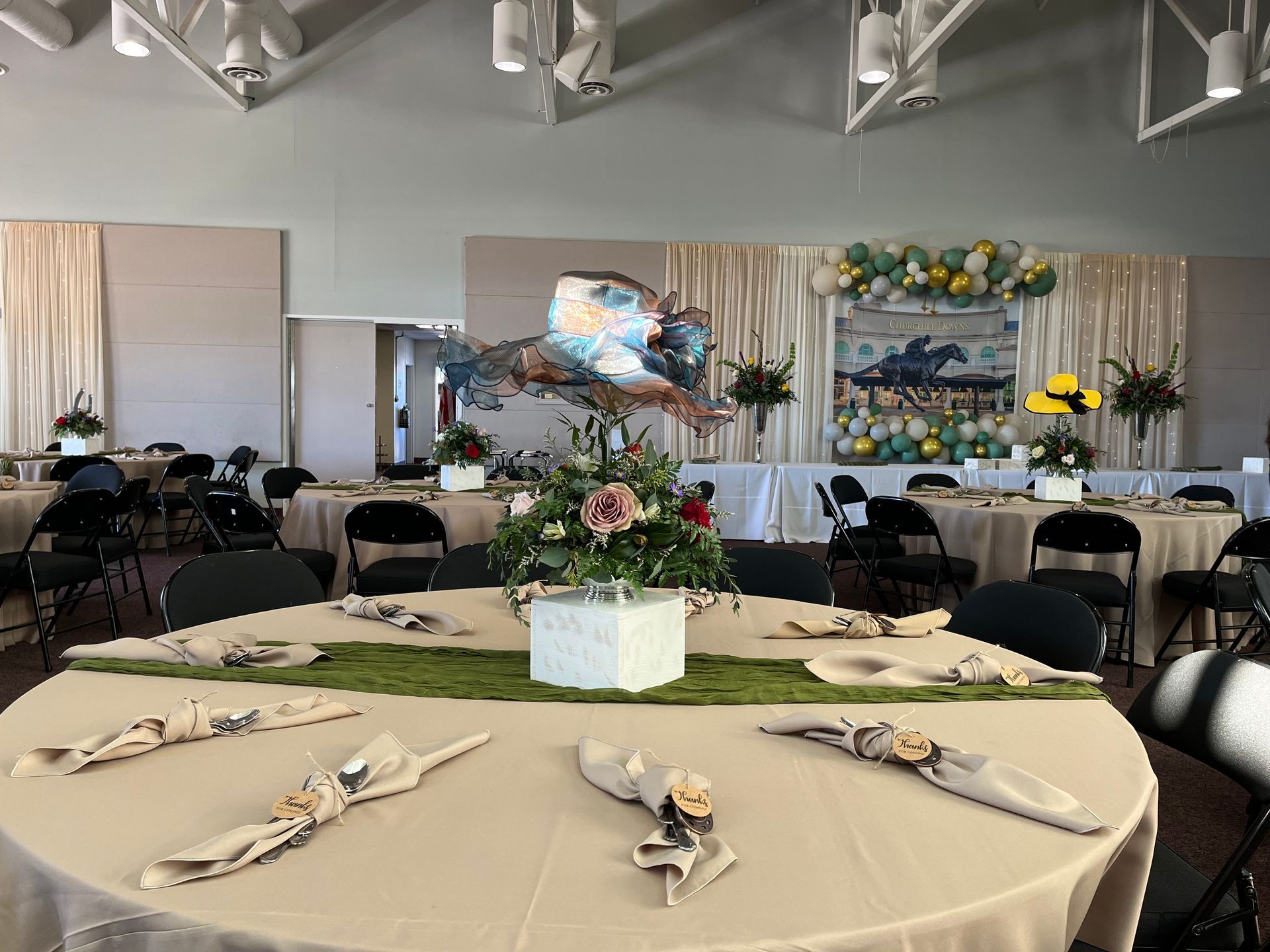 A large room with tables and chairs set up for a wedding reception.