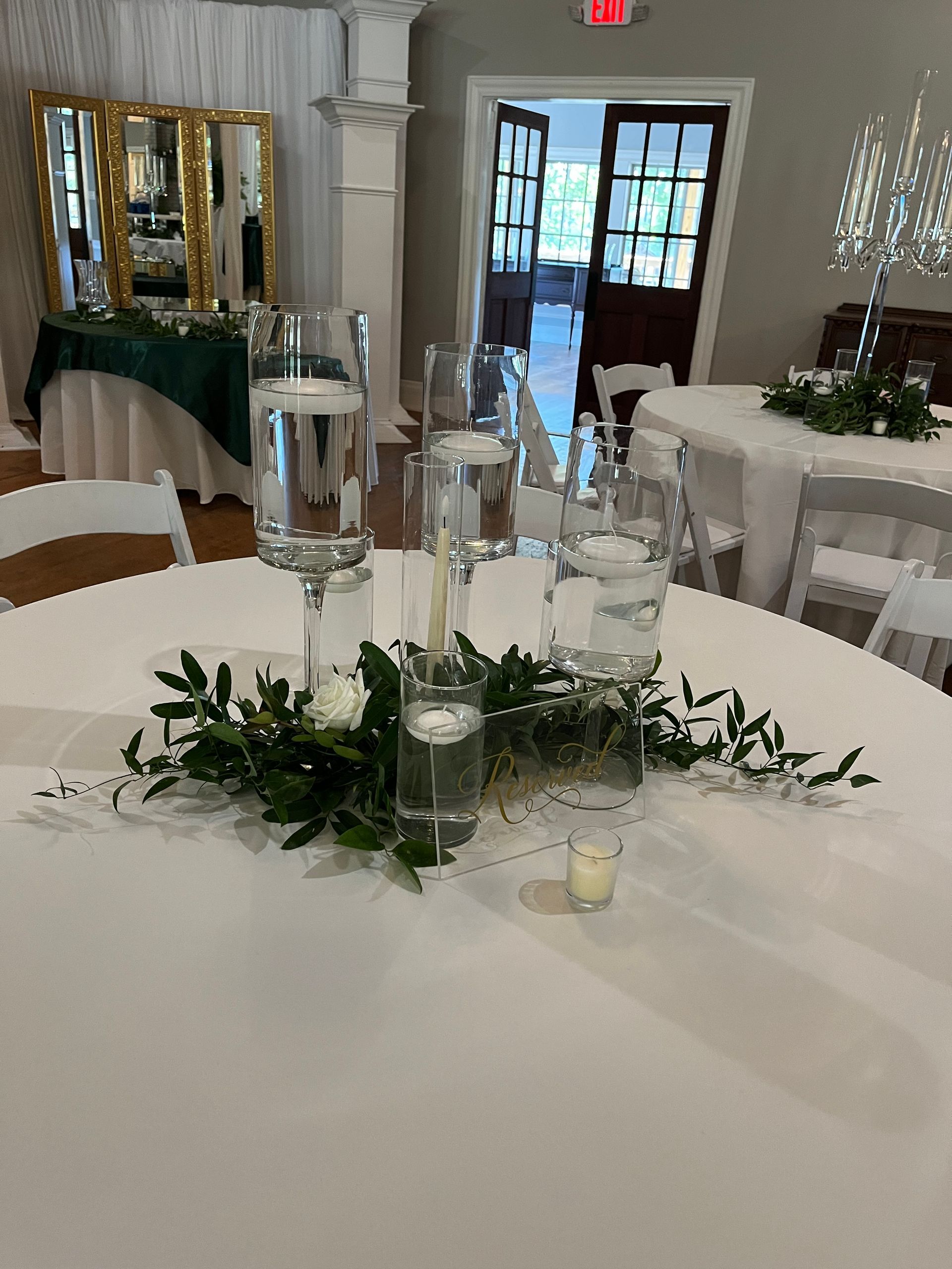 A table with a vase of flowers and candles on it.