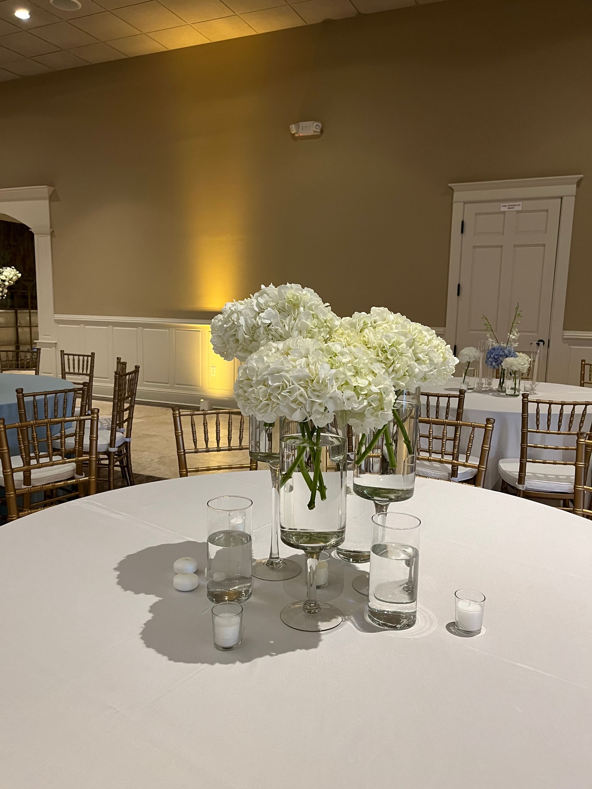A table with a vase of flowers and candles on it