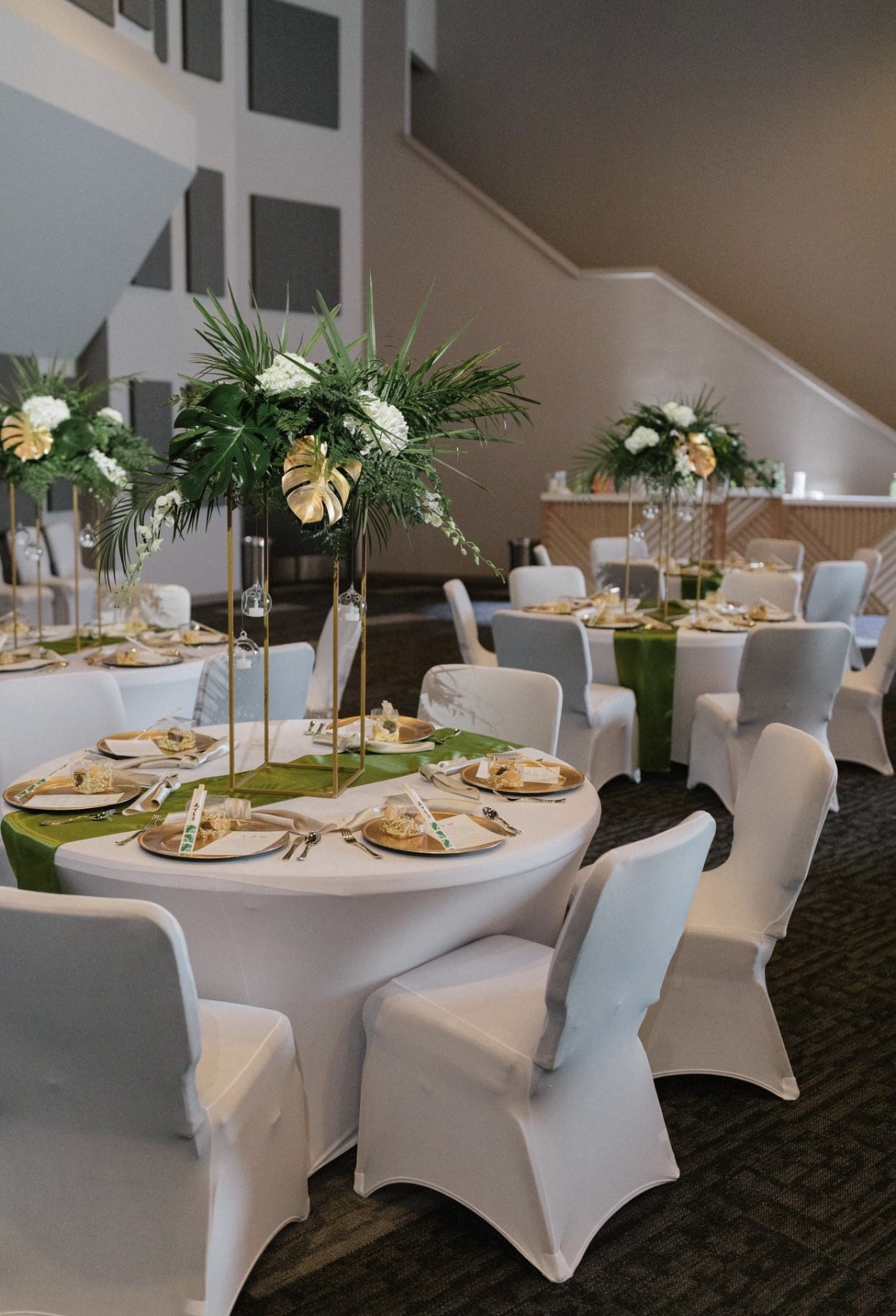 A room filled with tables and chairs set up for a wedding reception.