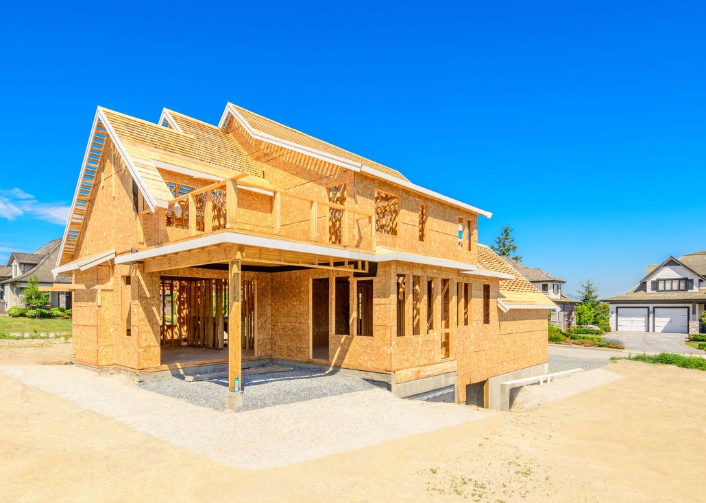Partially built wooden house under construction on a sunny day