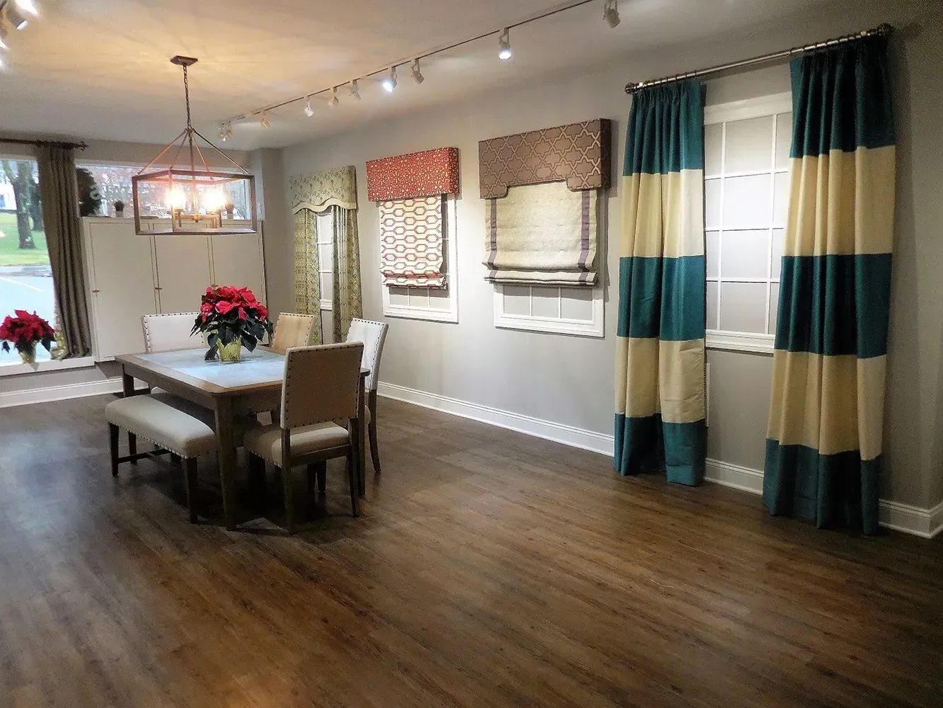 Dining room with dark wood floor, table with chairs, window treatments displayed.