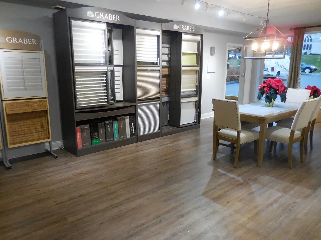 Showroom with window covering samples and a dining table set for display.