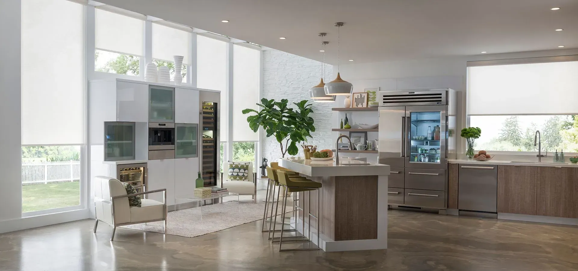 Modern kitchen with large windows, island with stools, and stainless steel appliances.