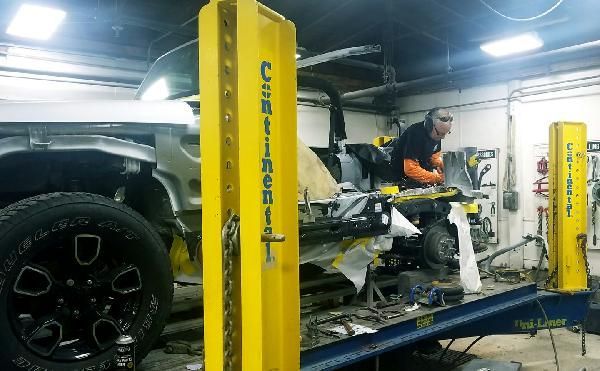 A man is working on a truck in a garage.