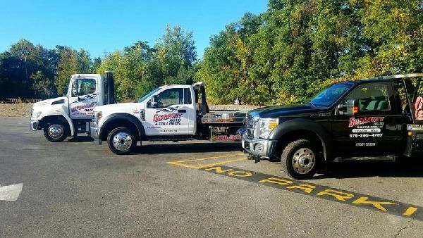 Two tow trucks are parked.