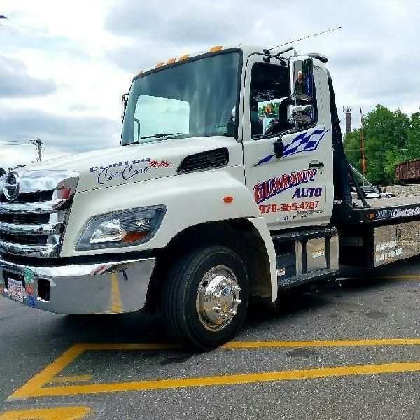 A white tow truck is parked in a parking lot.