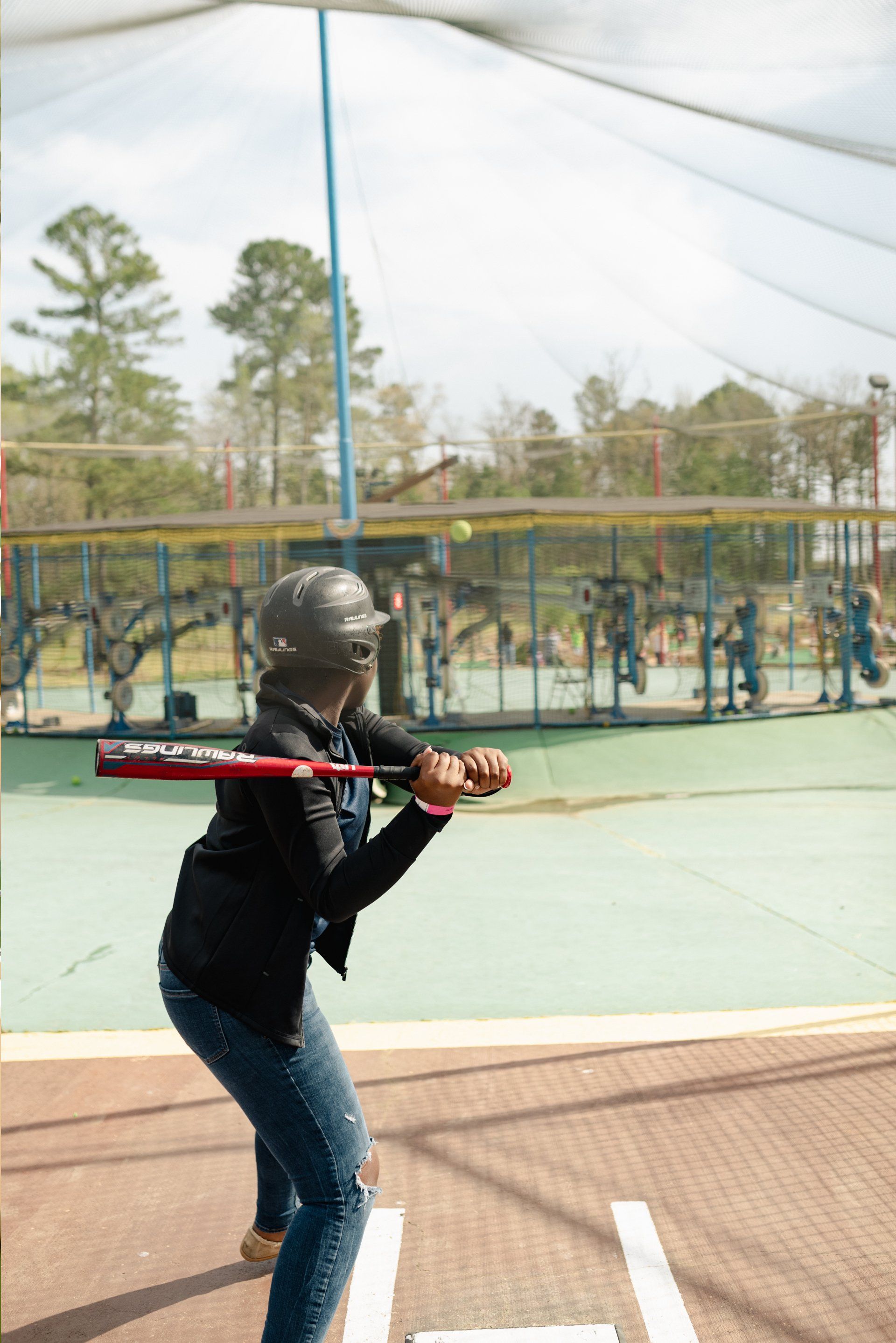 Teen with Black Hoodie Batting Cage