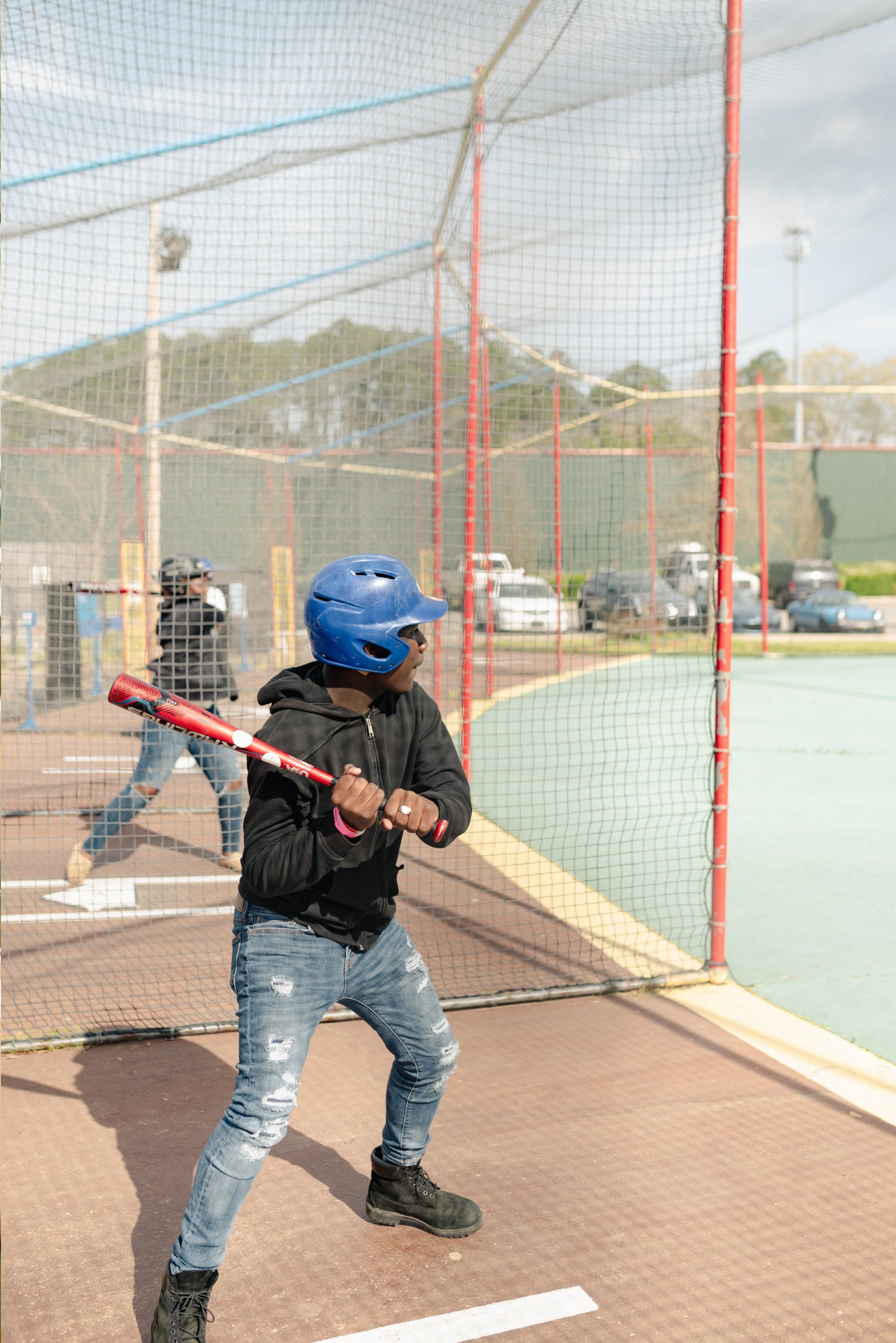 Teen with Black Hoodie Batting Cage