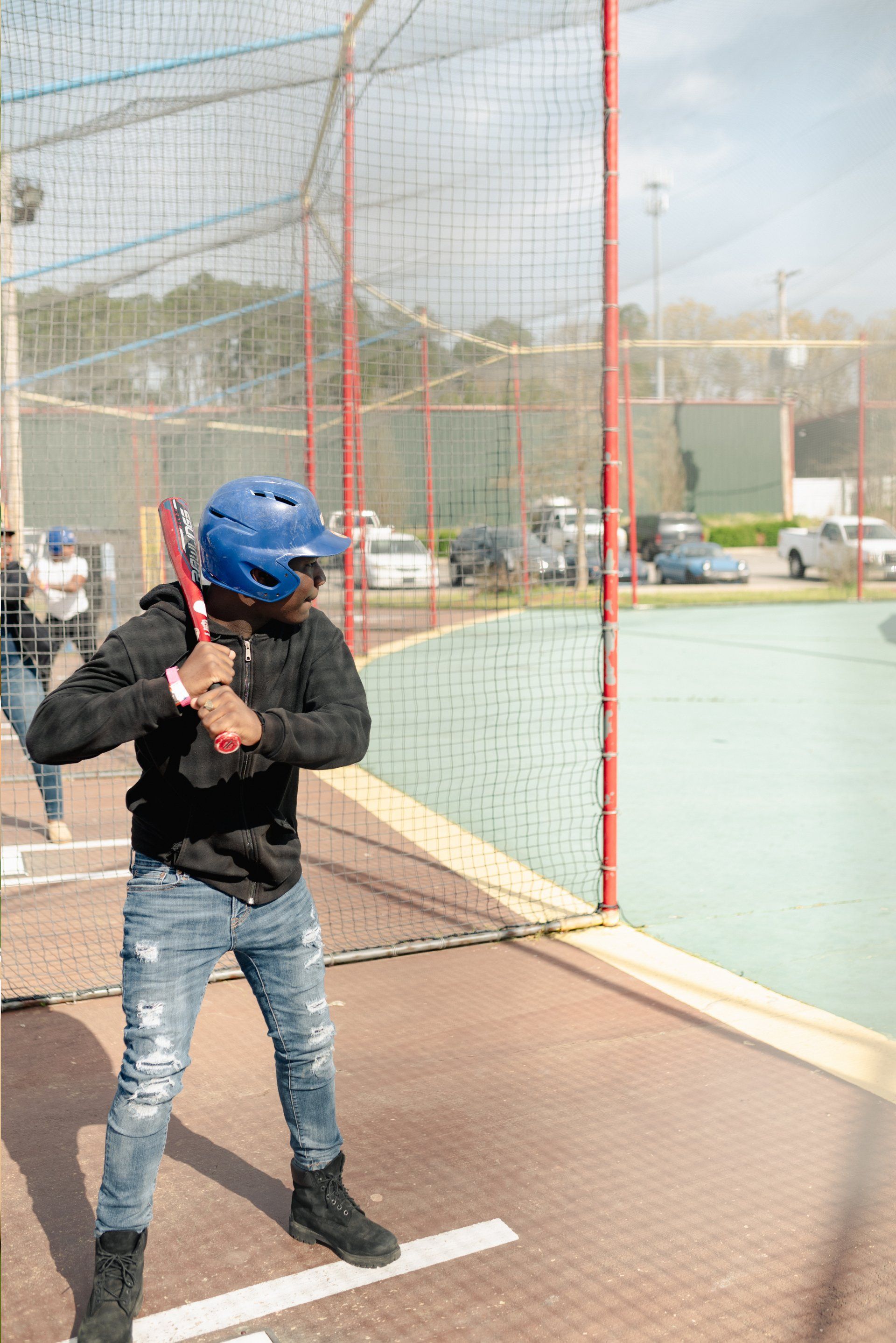 Teen with Black Hoodie Batting Cage