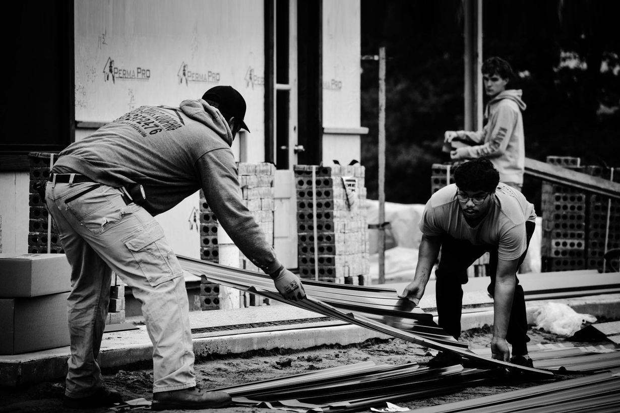 Construction workers laying track outside a building.