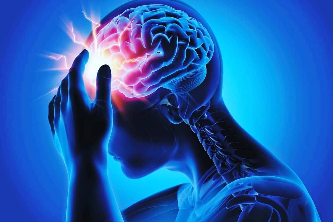 Silhouetted person holding head with glowing brain and pain effect in blue background