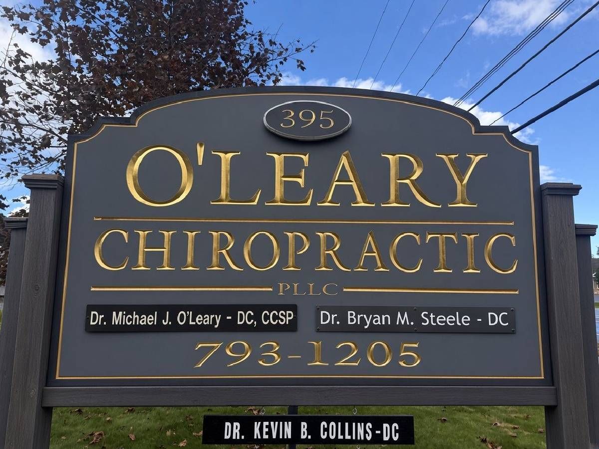 O'Leary Chiropractic sign with gold lettering and phone number 793-1205 on a roadside monument sign