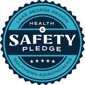 Lake George Region Health and Safety Pledge badge logo with teal and navy design and stars, Southern Adirondacks