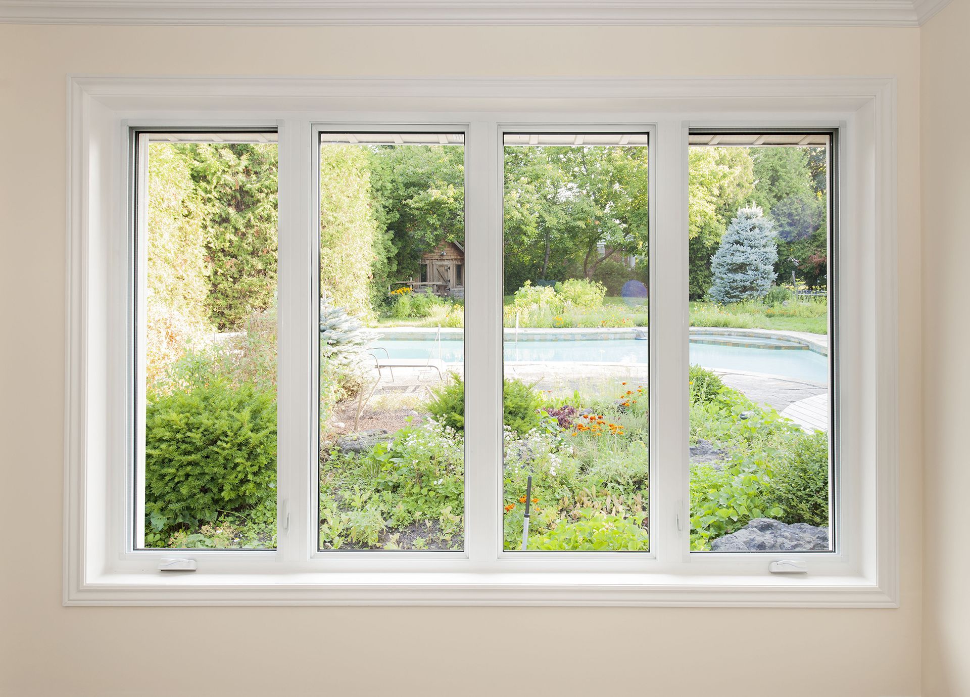 White-framed window overlooking a bright garden and driveway outside