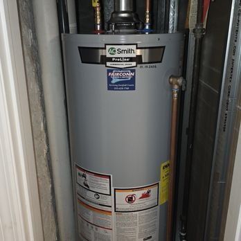 Gray Smith water heater in a utility closet with visible pipes and labels