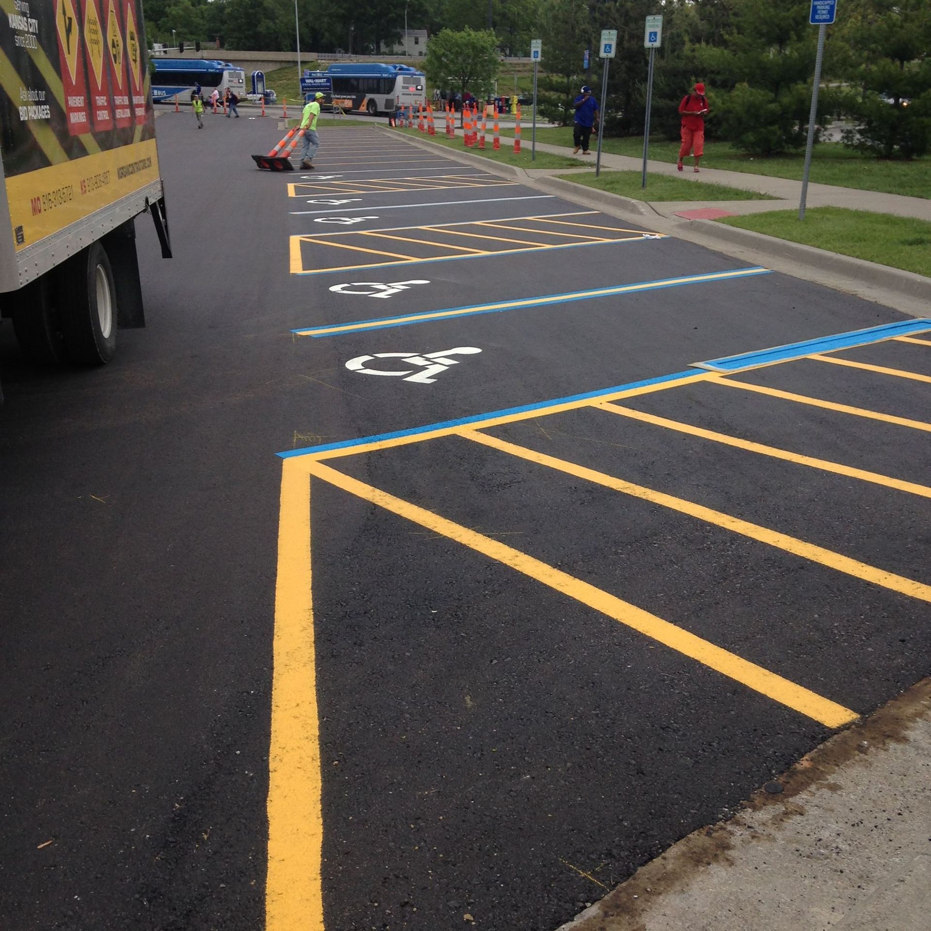 Newly painted parking lot with yellow and blue lines, and accessible parking spaces marked.
