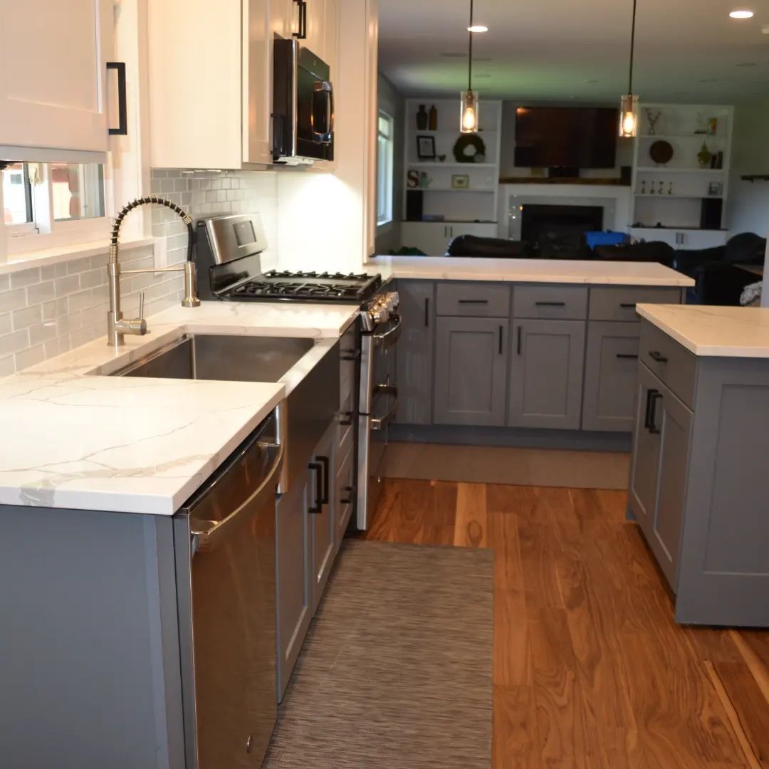 A kitchen with gray cabinets and white counter tops