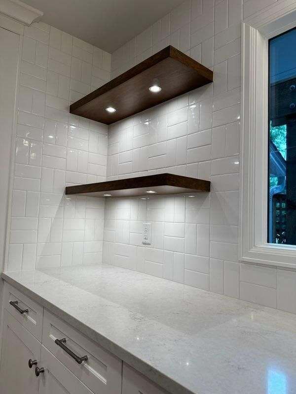 A kitchen with two wooden shelves and a window