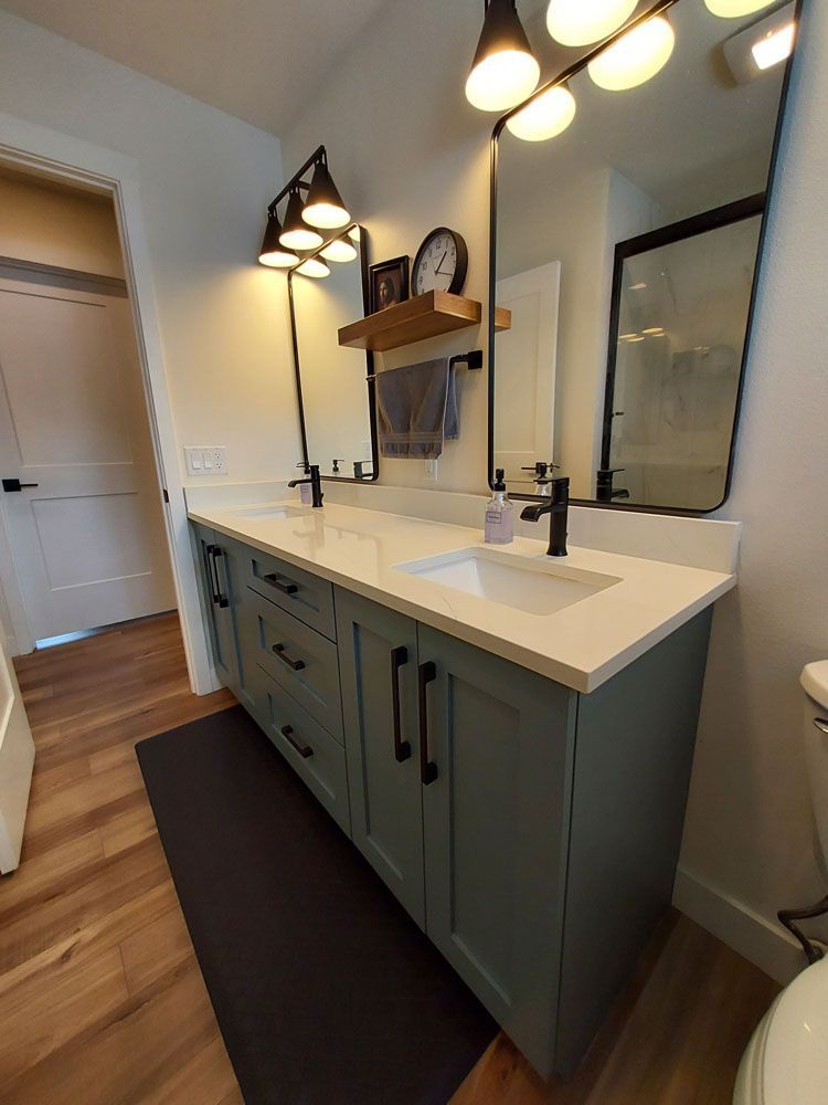 A bathroom with two sinks, a toilet, and a mirror