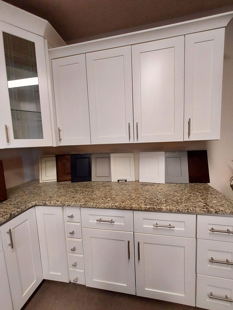 A kitchen with white cabinets and granite counter tops