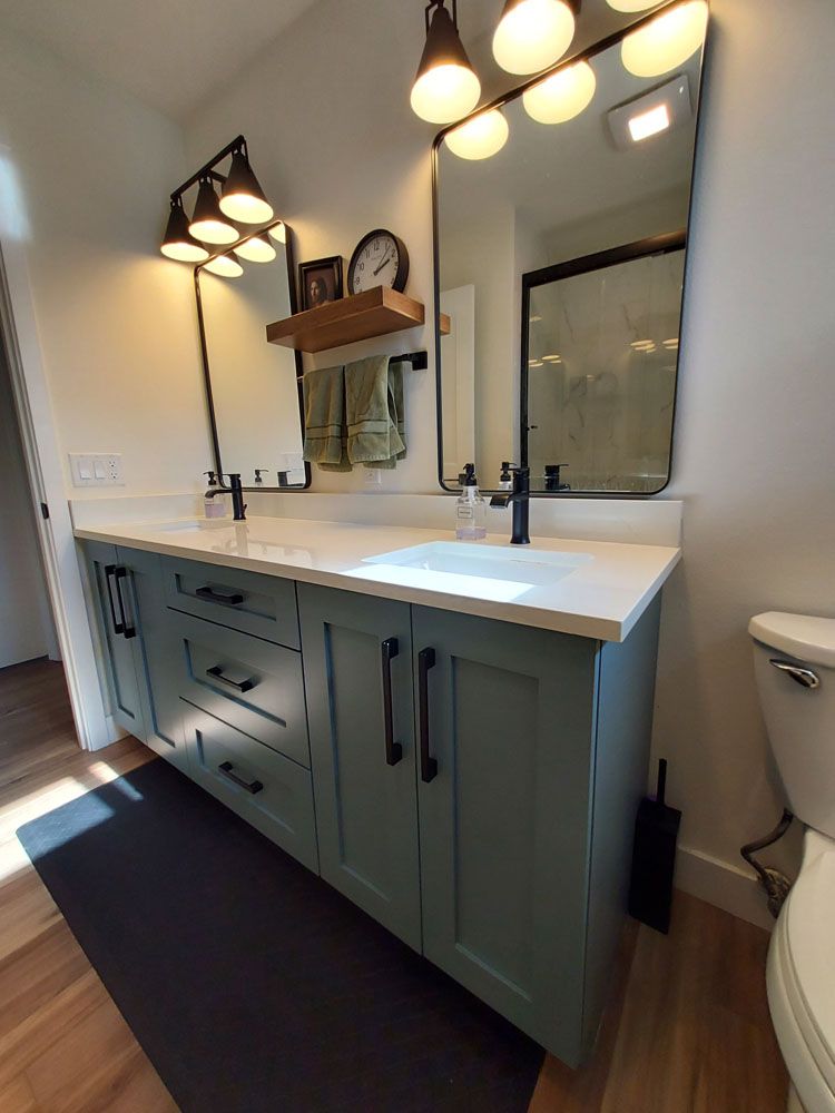 A bathroom with two sinks, a toilet, and a mirror
