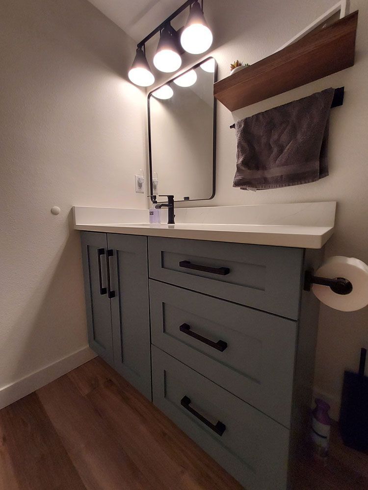 A bathroom with a sink, mirror, and towel rack