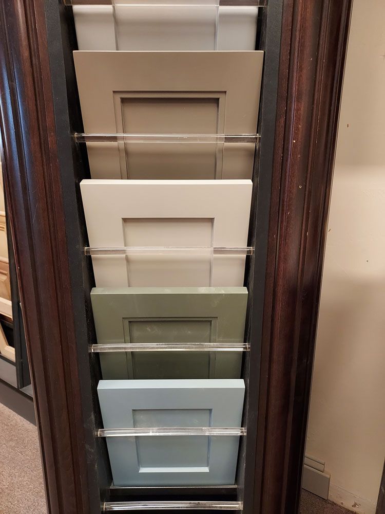 A display case filled with different colored cabinet doors