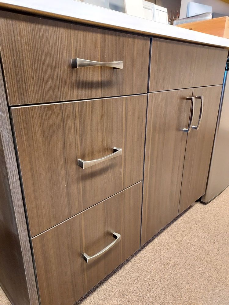 A wooden cabinet with drawers and cabinet doors in a kitchen