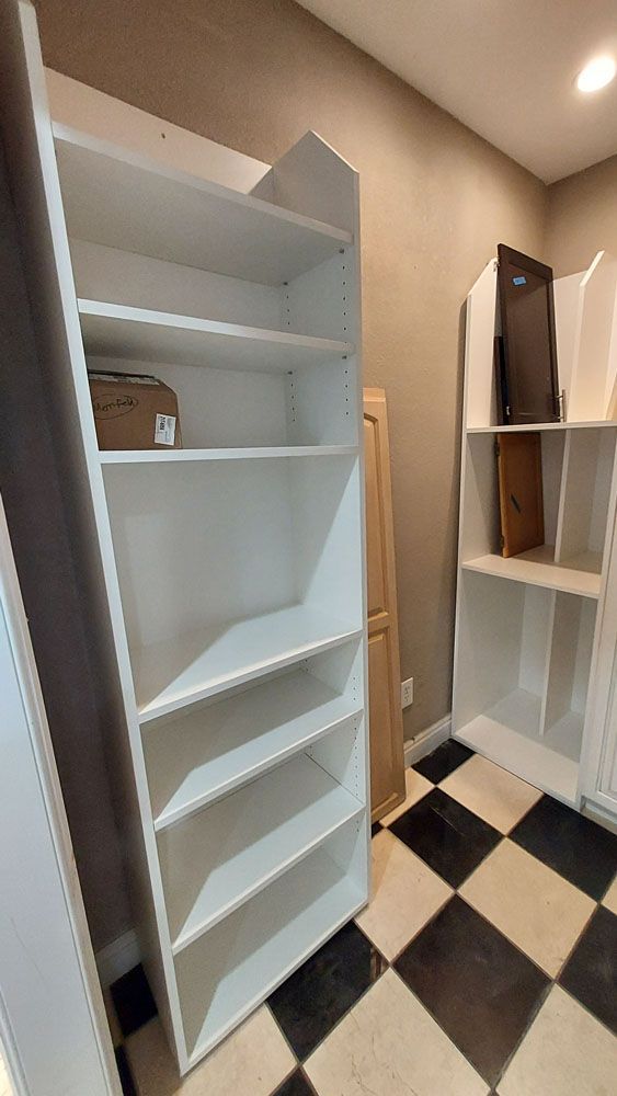 A room with white shelves and a checkered floor