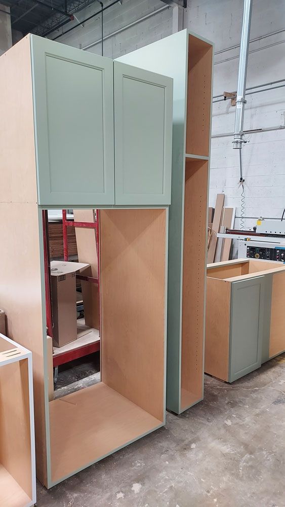 A row of wooden cabinets are being built in a factory