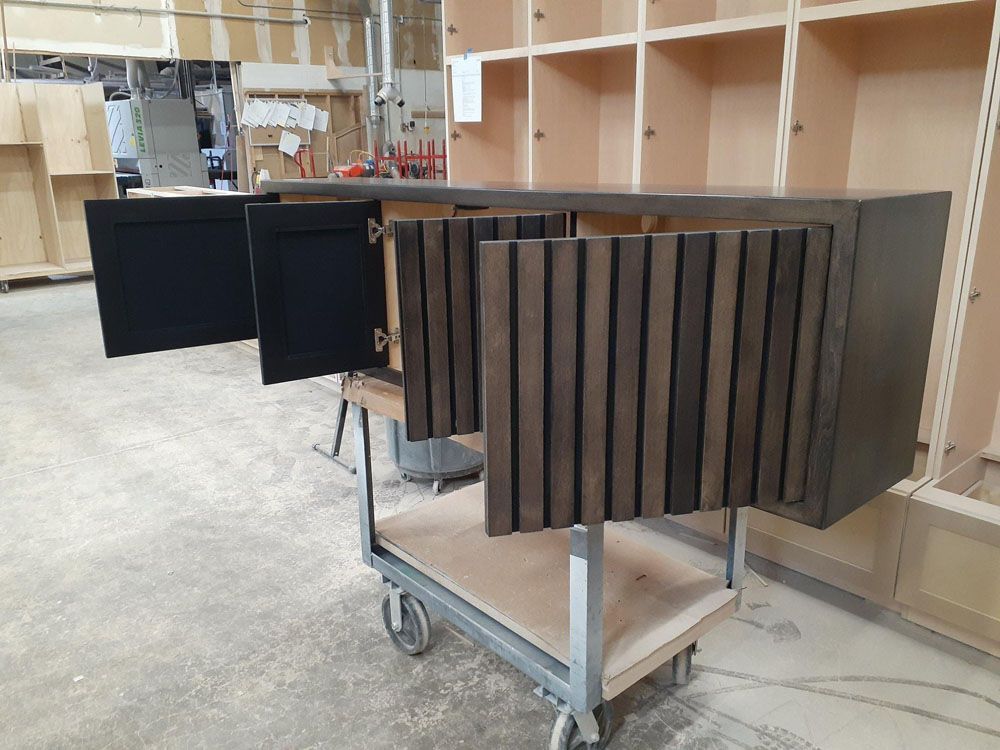 A wooden cabinet is sitting on a cart in a warehouse
