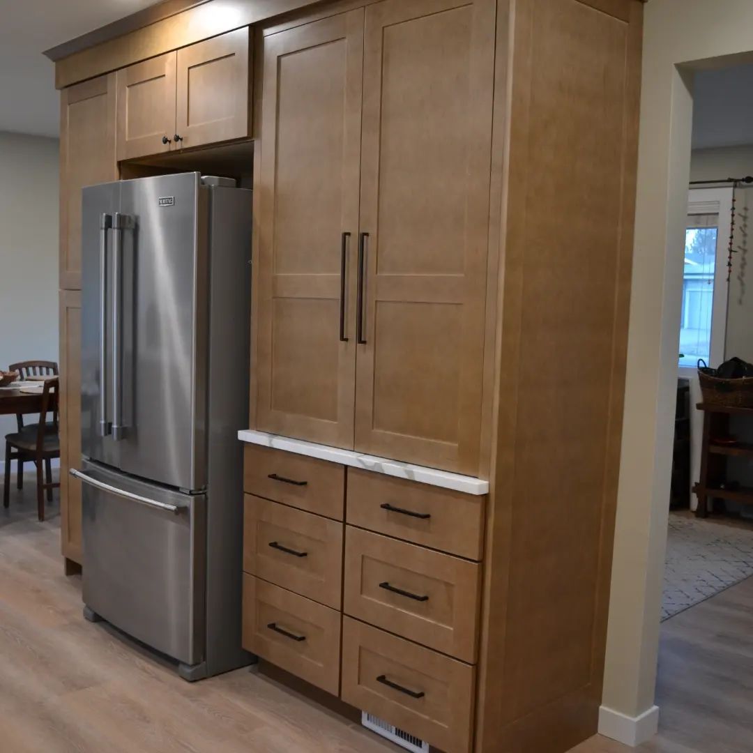 A kitchen with wooden cabinets and a stainless steel refrigerator