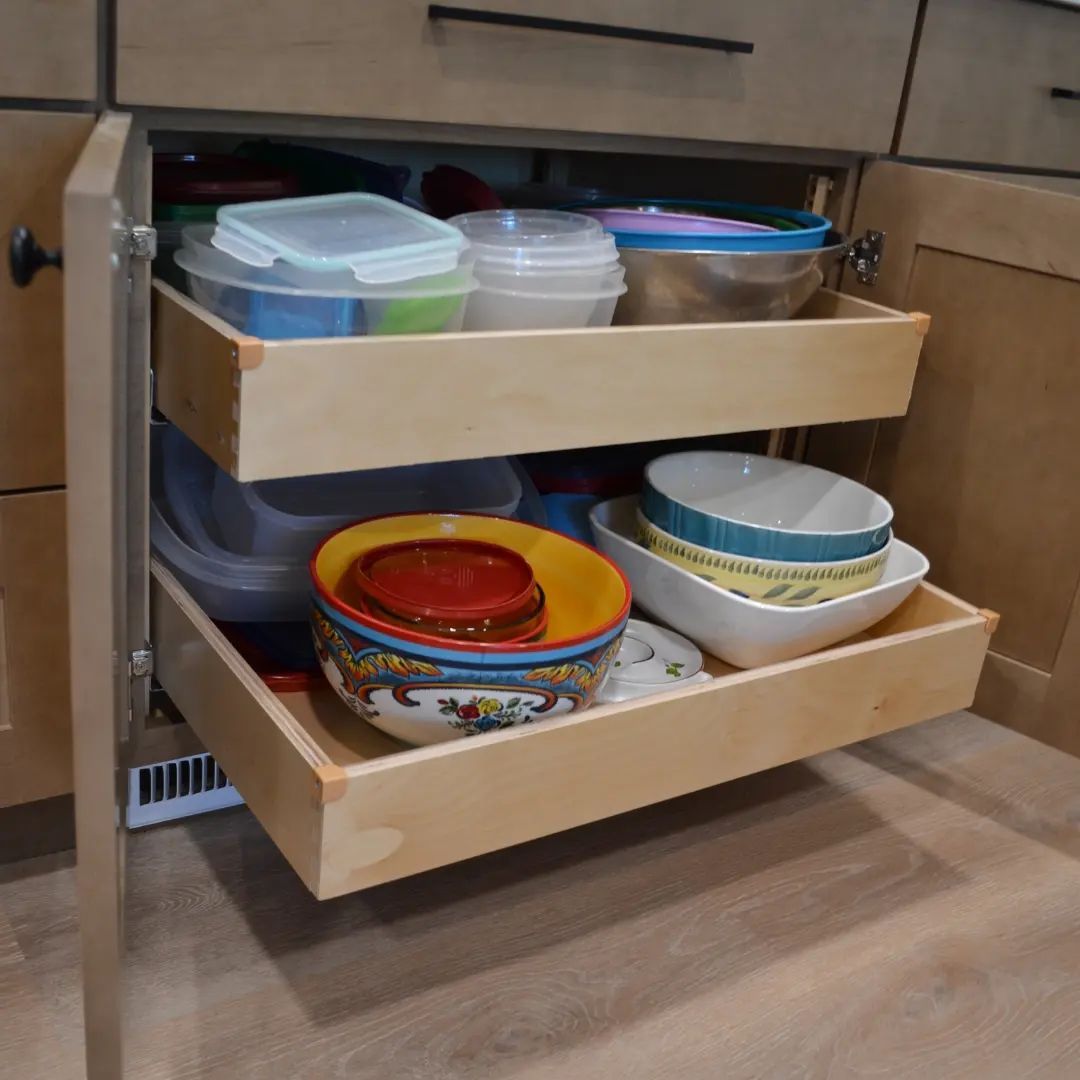 A kitchen drawer filled with bowls and plastic containers
