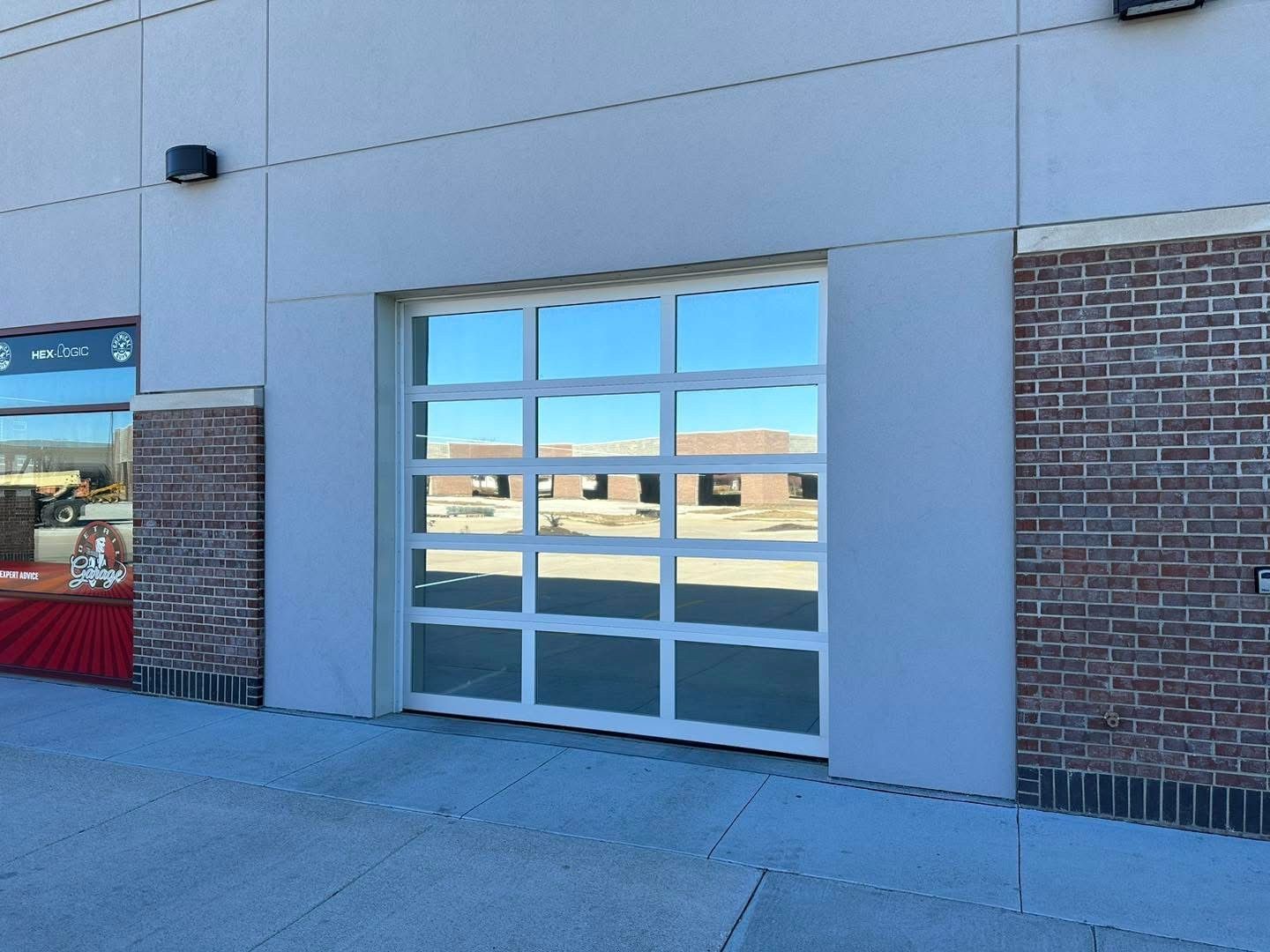 Storefront with a large glass window and blue-gray exterior wall on a sidewalk.
