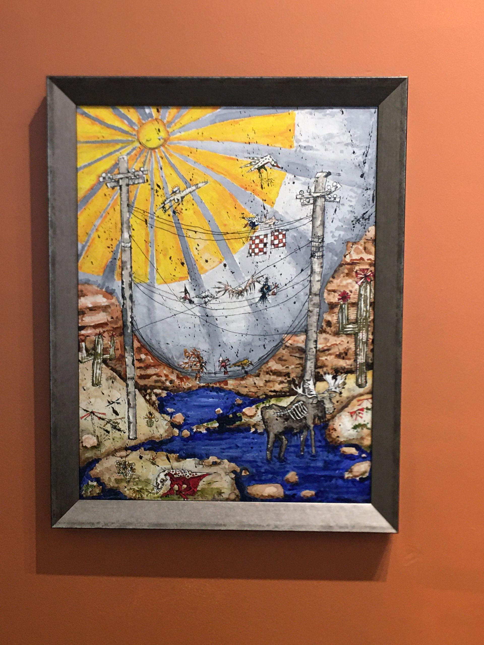 A framed painting of a moose in the desert