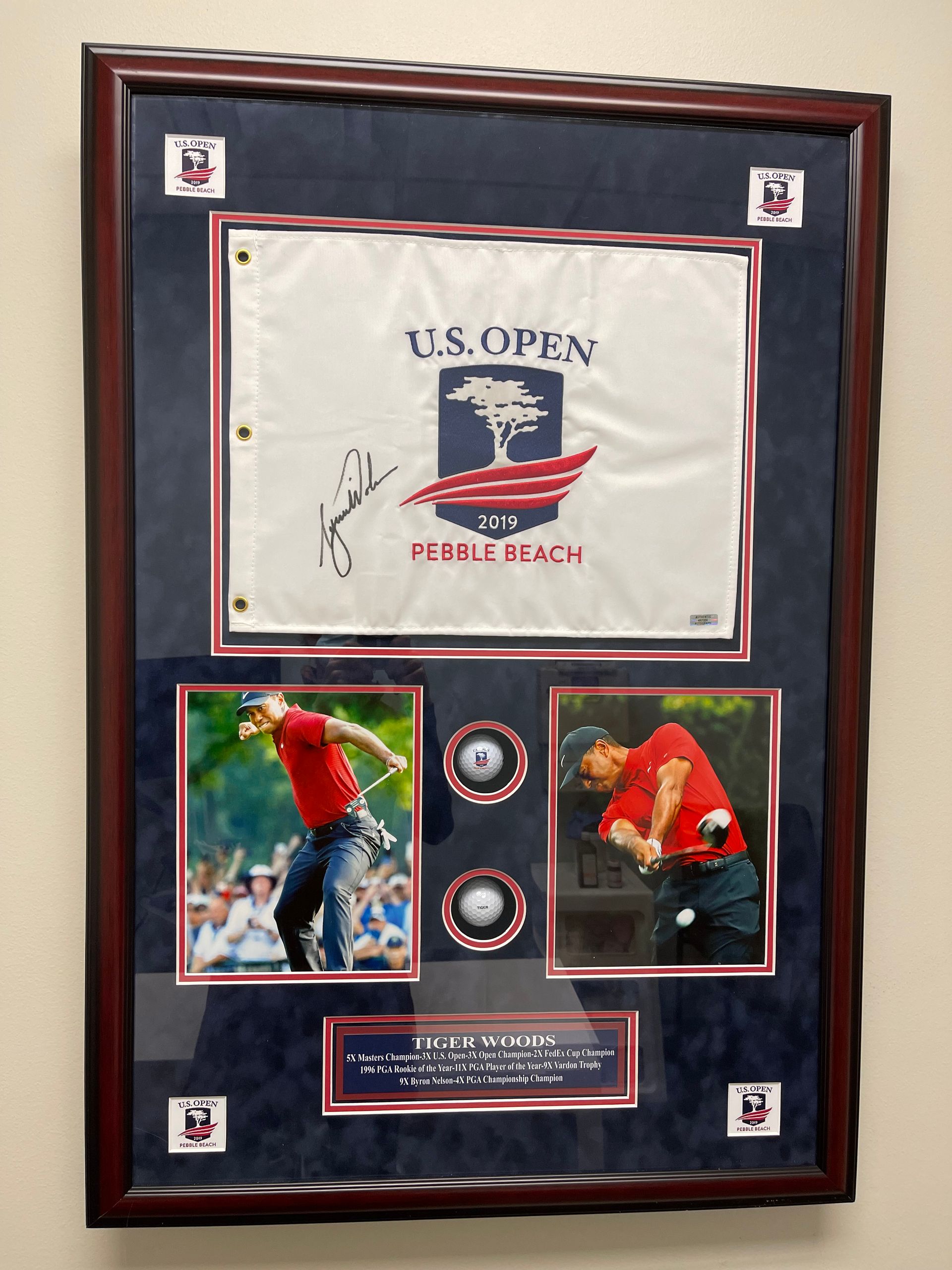 A framed us open golf flag hanging on a wall