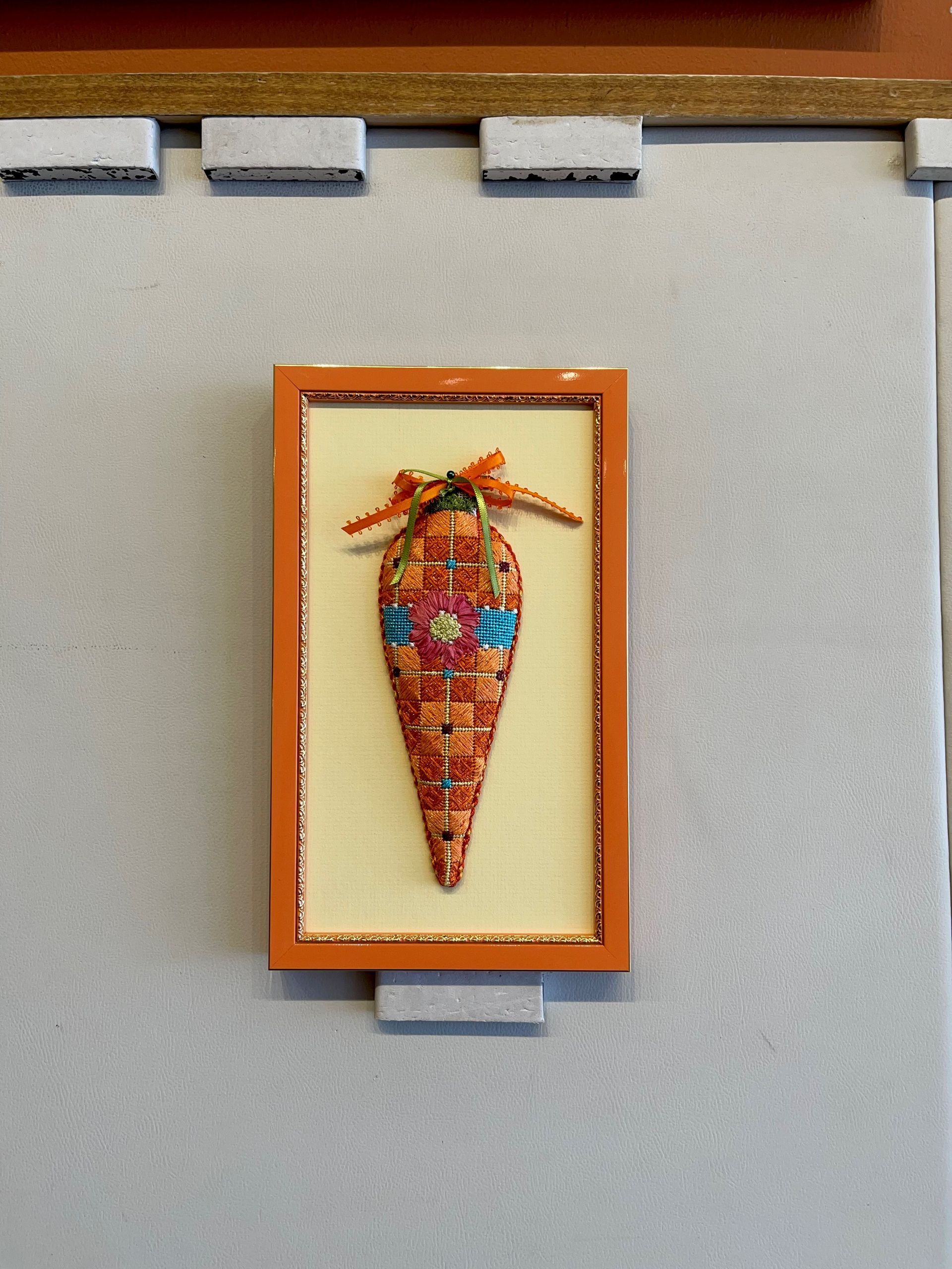 A picture of a carrot in a frame on a wall