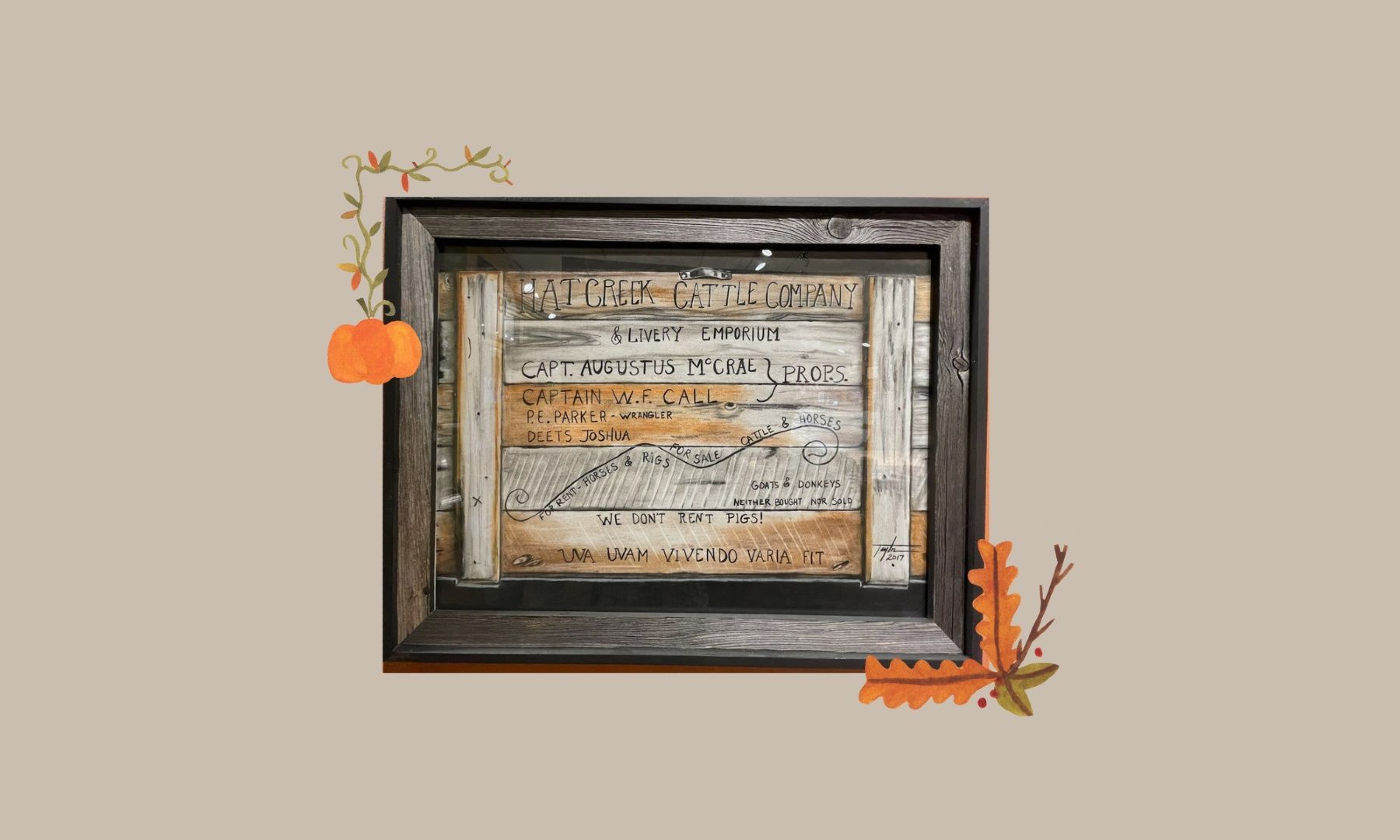 A picture frame with a pumpkin and leaves on it.