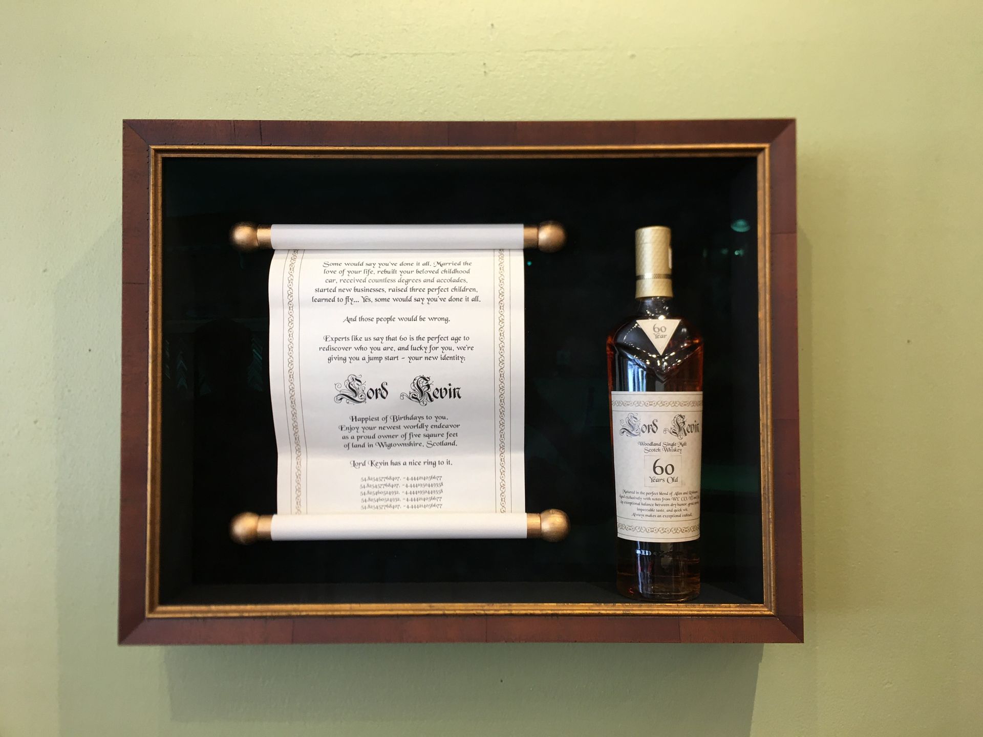 A bottle of scotch sits in a display case next to a scroll
