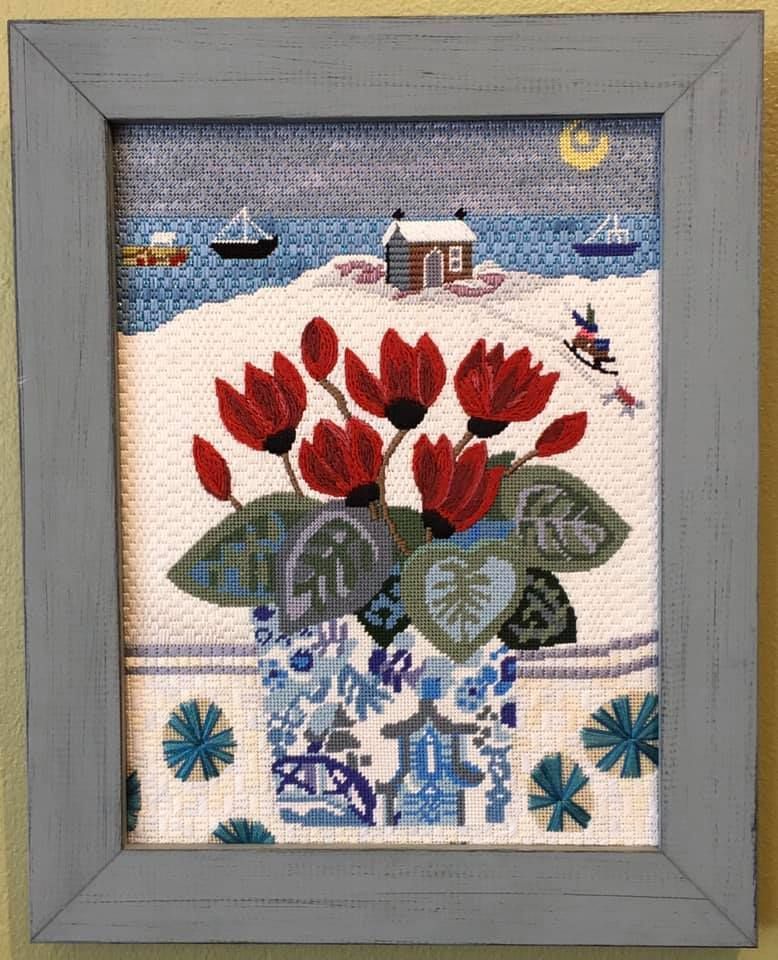 A painting of red flowers in a blue and white vase