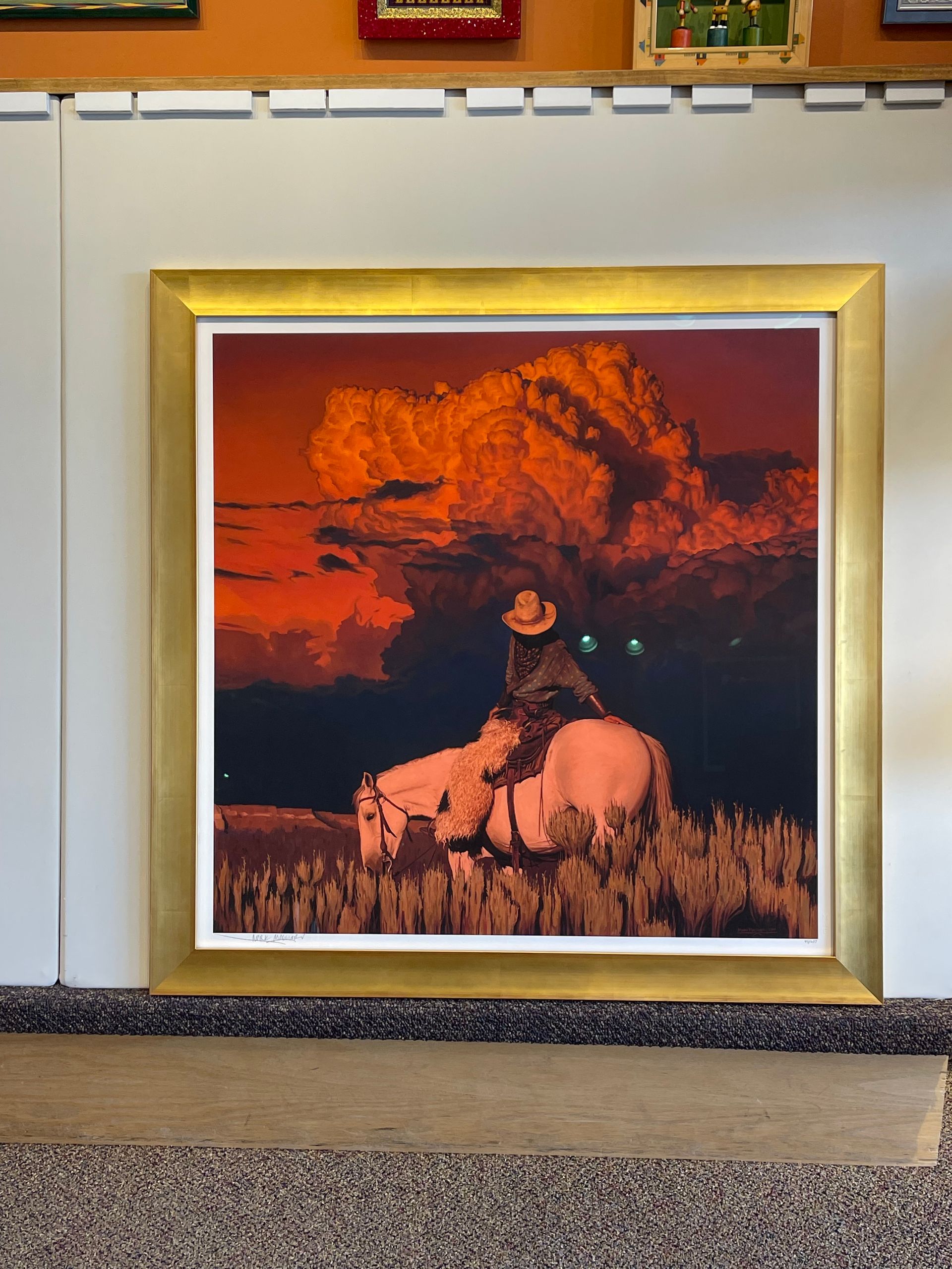 A framed painting of a man riding a horse