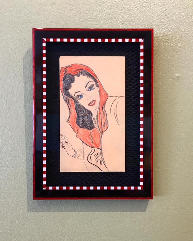 A framed picture of a woman wearing a red scarf