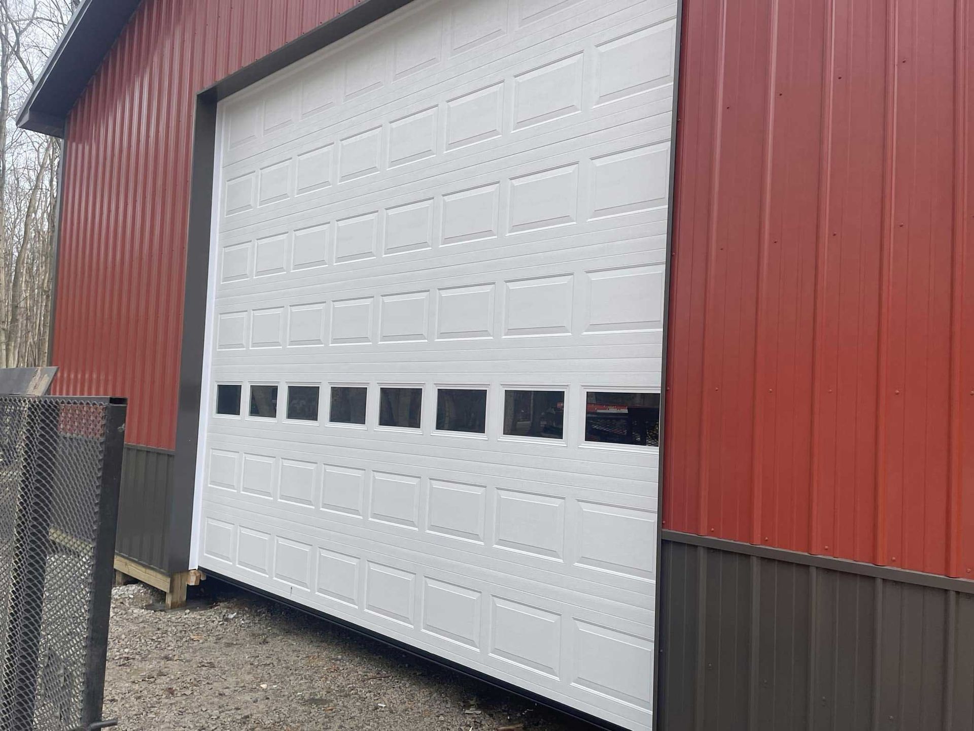 Red and brown building with a large white garage door; black windows near the top.