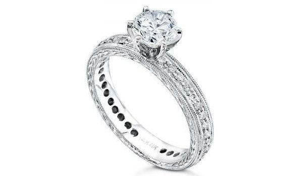 a white gold engagement ring with a diamond in the center on a white background .