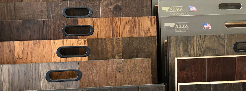 A variety of wooden flooring samples are stacked on top of each other.