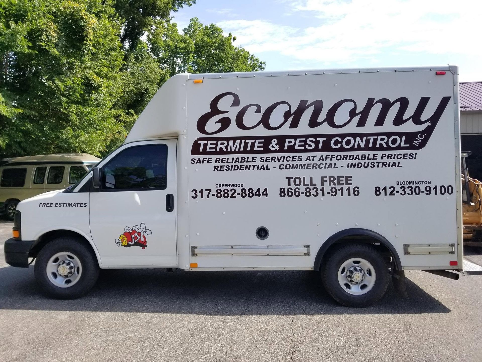 White Economy Termite & Pest Control truck parked outdoors with company phone numbers on the side
