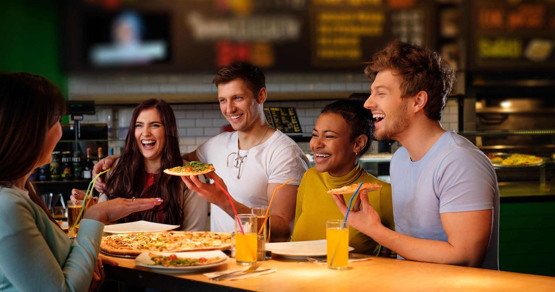 A person is taking a slice of pizza.